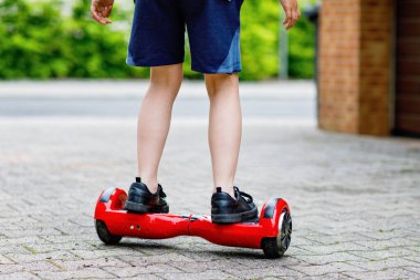 Ufaklık havada süzülüyor. Modern denge kaykayı kullanan çocuk. Egzersiz ve çocuklar için spor, çocuklar için açık hava aktivitesi