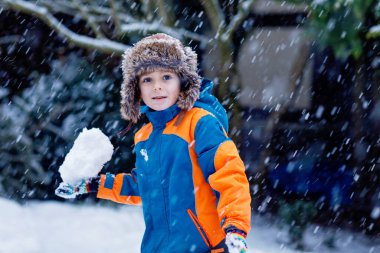 Kar yağarken kızak kayan iki çocuk. Kardeşler birlikte kızağa biniyor. Karlı kış parkında dışarıda oynayan ikizler. Gerçek hayat, gerçek insanlar, aktif aile tatili eğlencesi..