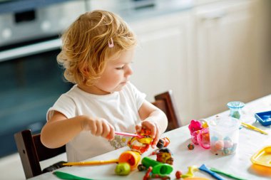 Evinde renkli kille sevimli, küçük bir kız. Sağlıklı bir bebek çocuk yuvasında ya da oyun okulunda hamur oynarken oyuncak yaratıyor. Kil kalıbı çıkaran küçük bir çocuk, yaratıcı aktivite.