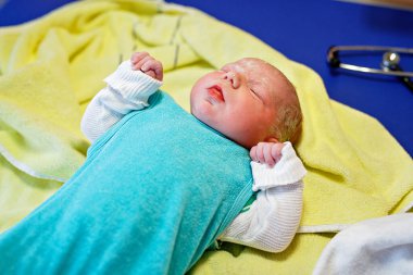 Yeni doğan çocuk doğumdan saniyeler ve dakikalar sonra ağlıyor. Havlu üzerinde küçük şirin bir kız bebek. Yeni hayat, başlangıç, sağlık hizmetleri