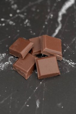 Süt çikolata parçaları arka planda izole edilmiş.