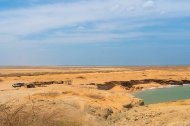 Yazın güneşi gökyüzünde ve kumsalın kumları, manzaranın