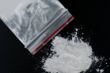 Kokain ya da diğer yasadışı uyuşturucular, beyaz toz, şırınga, siyah parlak arka planda izole