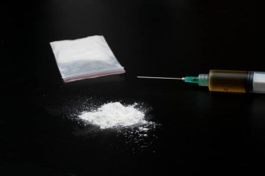 Kokain ya da diğer yasadışı uyuşturucular, beyaz toz, şırınga, siyah parlak arka planda izole