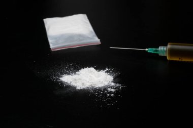 Kokain ya da diğer yasadışı uyuşturucular, beyaz toz, şırınga, siyah parlak arka planda izole