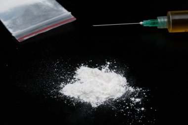 Kokain ya da diğer yasadışı uyuşturucular, beyaz toz, şırınga, siyah parlak arka planda izole