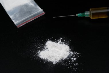 Kokain ya da diğer yasadışı uyuşturucular, beyaz toz, şırınga, siyah parlak arka planda izole