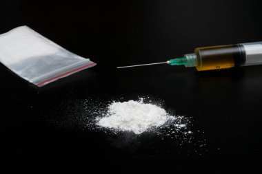 Kokain ya da diğer yasadışı uyuşturucular, beyaz toz, şırınga, siyah parlak arka planda izole
