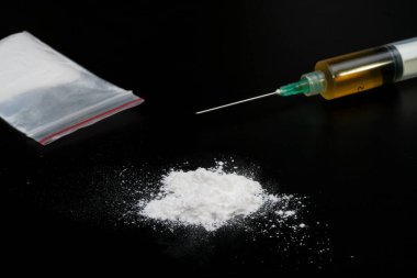 Kokain ya da diğer yasadışı uyuşturucular, beyaz toz, şırınga, siyah parlak arka planda izole