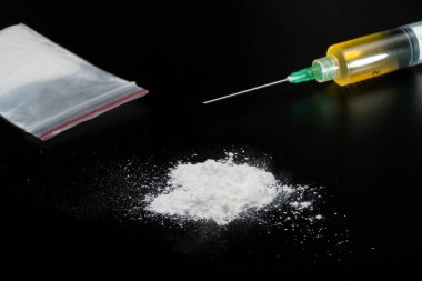 Kokain ya da diğer yasadışı uyuşturucular, beyaz toz, şırınga, siyah parlak arka planda izole