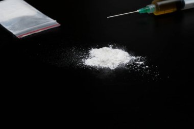 Kokain ya da diğer yasadışı uyuşturucular, beyaz toz, şırınga, siyah parlak arka planda izole