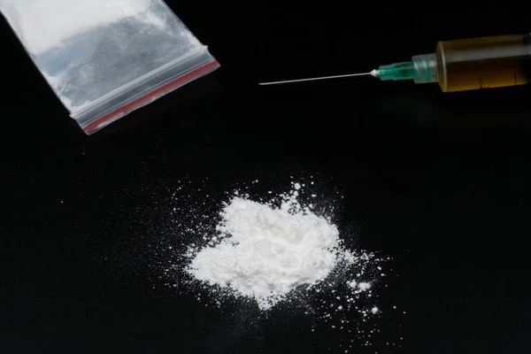 stock image Cocaine or other illegal drugs, white powder, syringe, isolated on black glossy background