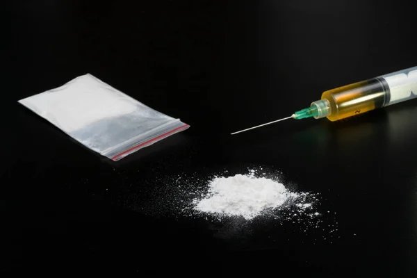 stock image Cocaine or other illegal drugs, white powder, syringe, isolated on black glossy background