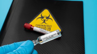 Doktor elinde COVID 19 Coronavirus aşısı tutuyor, örnek tüpte kan örneği, aşı ve şırınga enfeksiyonu COVID-19 'dan korunma, aşılama ve tedavi için kullanılıyor.