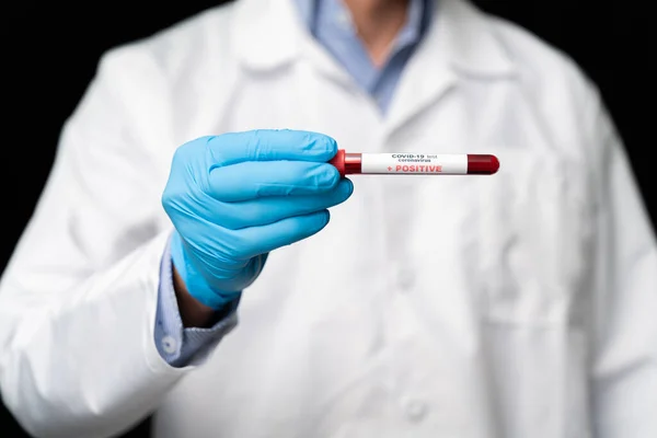 stock image Doctor holds COVID 19 Coronavirus vaccine in his hand, infected blood sample in the sample tube, Vaccine and syringe injection It use for prevention, immunization and treatment from COVID-19