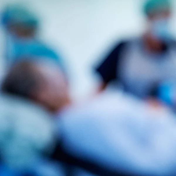 stock image London UK, November13 2022, Anonymous Blurred Doctors Or Medical Staff Working In A Hospital Wearing Blue Gowns And Protective Face Masks