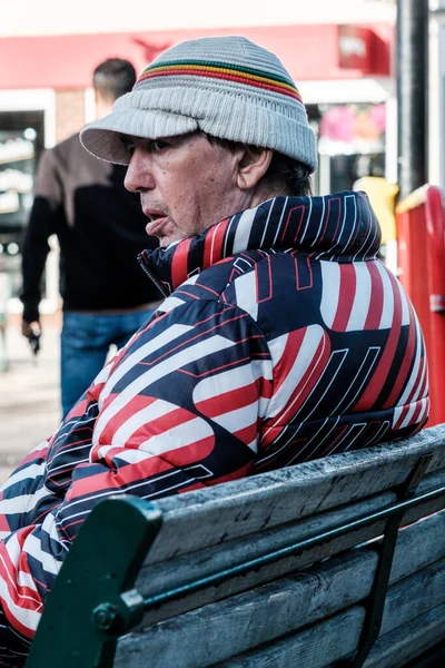 エプソム サリー ロンドン英国 11月20日2022 明るいパフジャケットとウールを身に着けている木製のベンチに座っているシニア男性は思慮深く 高価だった — ストック写真