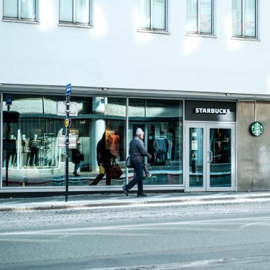Stavanger, Norveç, Mart 2023, Starbucks Kahve Dükkanı 'nın önünden geçen bir adam.