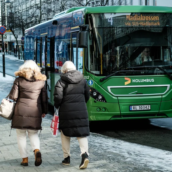 ノルウェーのスタバンガー2023年3月10日緑のコルンバスシングルデッキバスを歩く2人の中年女性 ストック写真