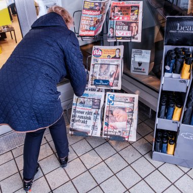 Sandnes, Norveç, 11 Mart 2023, Bir gazete bayiinden gazete almak için eğilen ya da eğilen kadın Sandnes