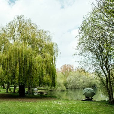 Kimliği belirsiz bekar bir adam gölün kıyısında tek başına balık tutuyor.