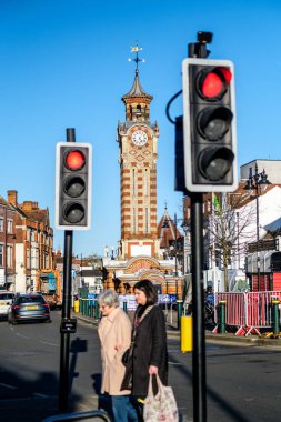 Epsom Surrey, İngiltere, 30 Mart 2024, Kırmızı ya da Durdur Trafik Işıkları Yoldan geçen İki Kadın Alışveriş Torbası Taşıyor