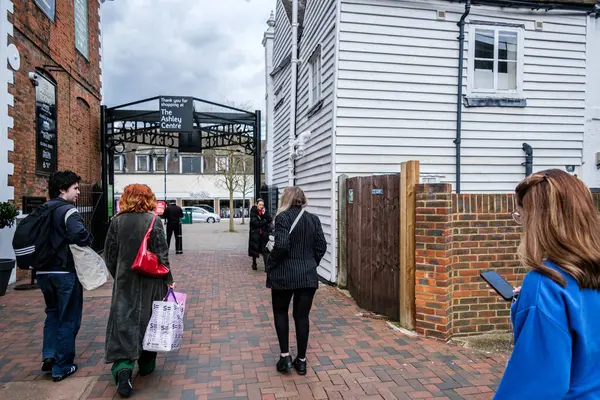 Epsom Surrey, İngiltere, Nisan 02 2024, Alışveriş Torbası Taşıyan Küçük İnsan Grubu Cep Telefonu Mesajı ile Yürüyen Kadın