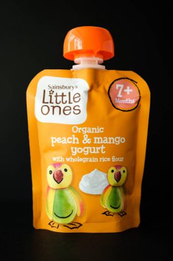 Londra İngiltere, 30 Nisan 2025, Sainsburys Küçükler Organik Şeftali ve Mango Yoğurt püresi ile kepekli pirinç unlu bebek maması