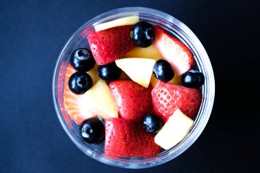 Londra İngiltere, 30 Mayıs 2025, Çilekli, mangolu ve yabanmersinli bir kase taze sağlıklı meyve salatası