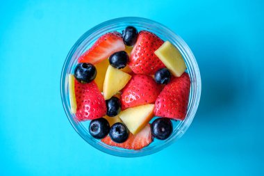 Londra İngiltere, 30 Mayıs 2025, Çilekli, mangolu ve yabanmersinli bir kase taze sağlıklı meyve salatası