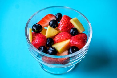 Londra İngiltere, 30 Mayıs 2025, Çilekli, mangolu ve yabanmersinli bir kase taze sağlıklı meyve salatası