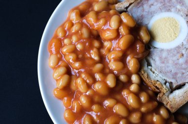 Londra İngiltere, Haziran 06 2025, Bir dilim domuz eti ve fırınlanmış fasulyeli yumurta klasik galası turtası.