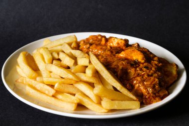 Londra İngiltere, Haziran 09 2025, Bir tabak Geleneksel Tavuk Tikka Masala with Chips