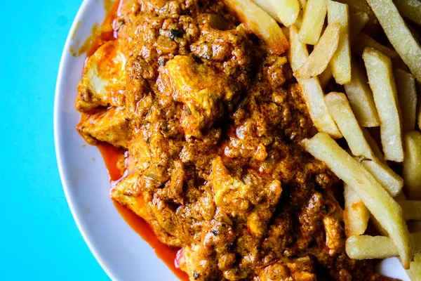 Londra İngiltere, Haziran 09 2025, Bir tabak Geleneksel Tavuk Tikka Masala with Chips