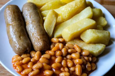 Londra İngiltere, 13 Haziran 2025, İngiliz favori domuz sosisi patates kızartması ve fırında fasulye sosu.