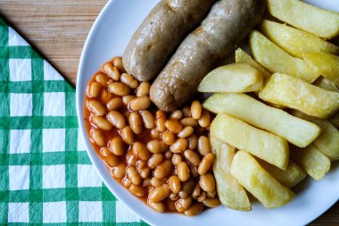 Londra İngiltere, 13 Haziran 2025, İngiliz favori domuz sosisi patates kızartması ve fırında fasulye sosu.