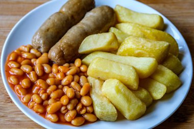 Londra İngiltere, 13 Haziran 2025, İngiliz favori domuz sosisi patates kızartması ve fırında fasulye sosu.