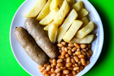 Londra İngiltere, 13 Haziran 2025, İngiliz favori domuz sosisi patates kızartması ve fırında fasulye sosu.