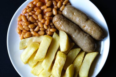 Londra İngiltere, 13 Haziran 2025, İngiliz favori domuz sosisi patates kızartması ve fırında fasulye sosu.