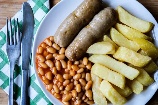 Londra İngiltere, 13 Haziran 2025, İngiliz favori domuz sosisi patates kızartması ve fırında fasulye sosu.