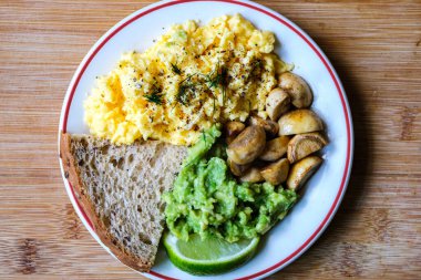 Londra İngiltere 25 Haziran 2025, Ezilmiş Avacado Musherooms ve Seed Bread ile çırpılmış Yumurtalar