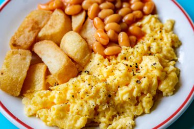 Londra 25 Haziran 2025, Domates soslu fırında yumurta ve kızarmış patates kızartması.