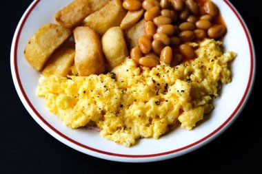 Londra 25 Haziran 2025, Domates soslu fırında yumurta ve kızarmış patates kızartması.