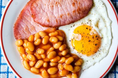 26 Haziran 2025 'te Londra' da domuz pastırmalı kızarmış yumurta ve domates soslu fasulye.