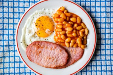 26 Haziran 2025 'te Londra' da domuz pastırmalı kızarmış yumurta ve domates soslu fasulye.