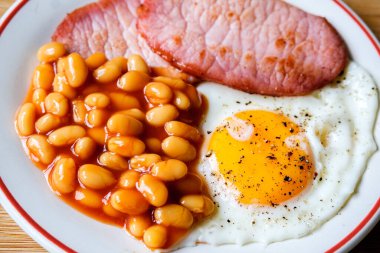 26 Haziran 2025 'te Londra' da domuz pastırmalı kızarmış yumurta ve domates soslu fasulye.