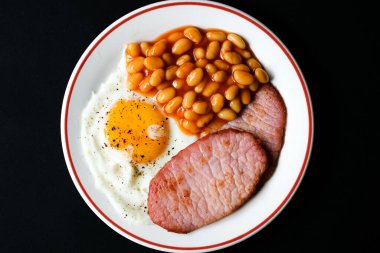 26 Haziran 2025 'te Londra' da domuz pastırmalı kızarmış yumurta ve domates soslu fasulye.