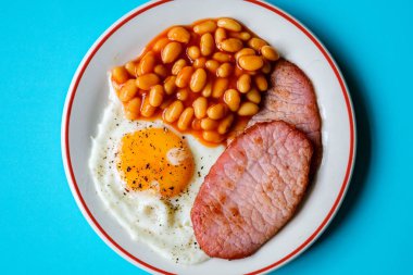 26 Haziran 2025 'te Londra' da domuz pastırmalı kızarmış yumurta ve domates soslu fasulye.