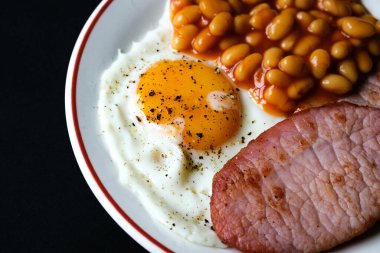 26 Haziran 2025 'te Londra' da domuz pastırmalı kızarmış yumurta ve domates soslu fasulye.