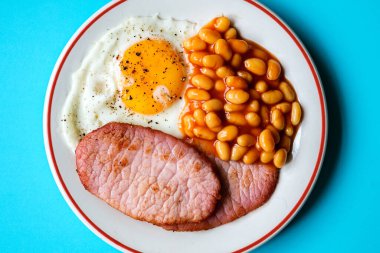 26 Haziran 2025 'te Londra' da domuz pastırmalı kızarmış yumurta ve domates soslu fasulye.